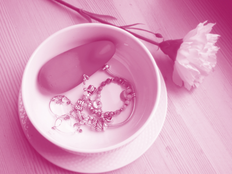 hands-free vibrator in white bowl with jewelry with flower next to it