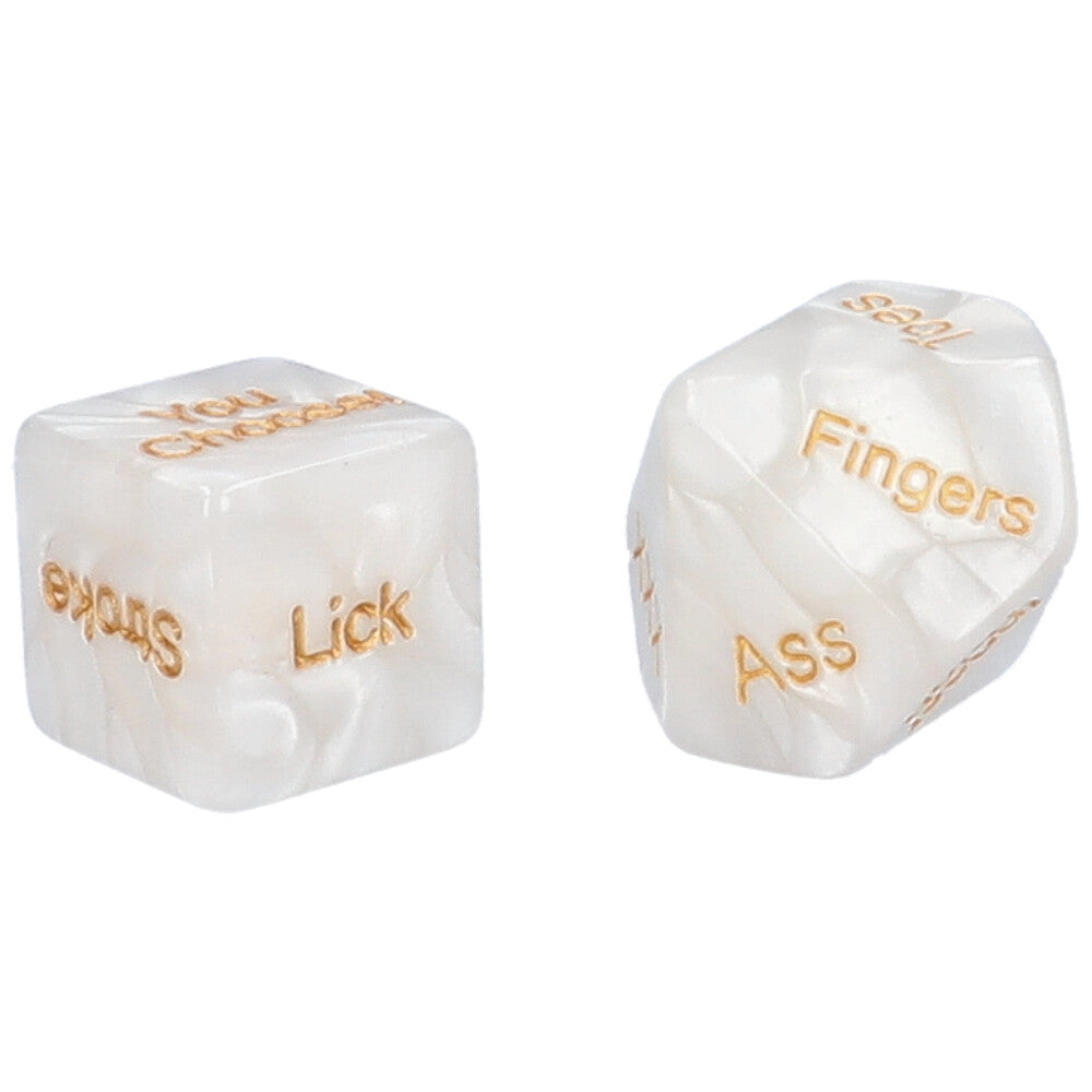 A pair of white & gold foreplay dice with “stroke”, “you choose” and “lick” showing on one die and “ass”, “inner thigh”, and “fingers” showing on the other.