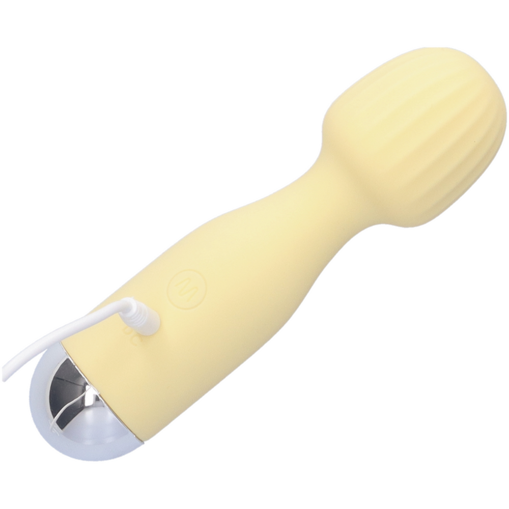 Image of Mini silicone rechargeable massage wand in the yellow color option on charger