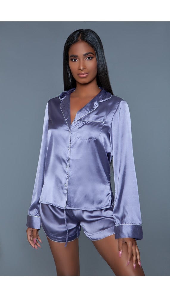 Model wearing 2 pc satin pajama set. Long sleeves top and shorts with silver piping facing forward